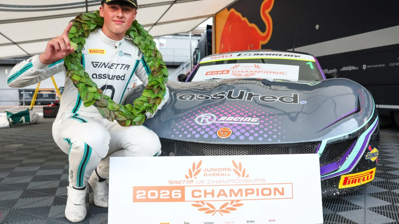 Lewis Goff, campion Ginetta Junior 2026, pozează cu coroana de lauri lângă mașina sa de curse R Racing.