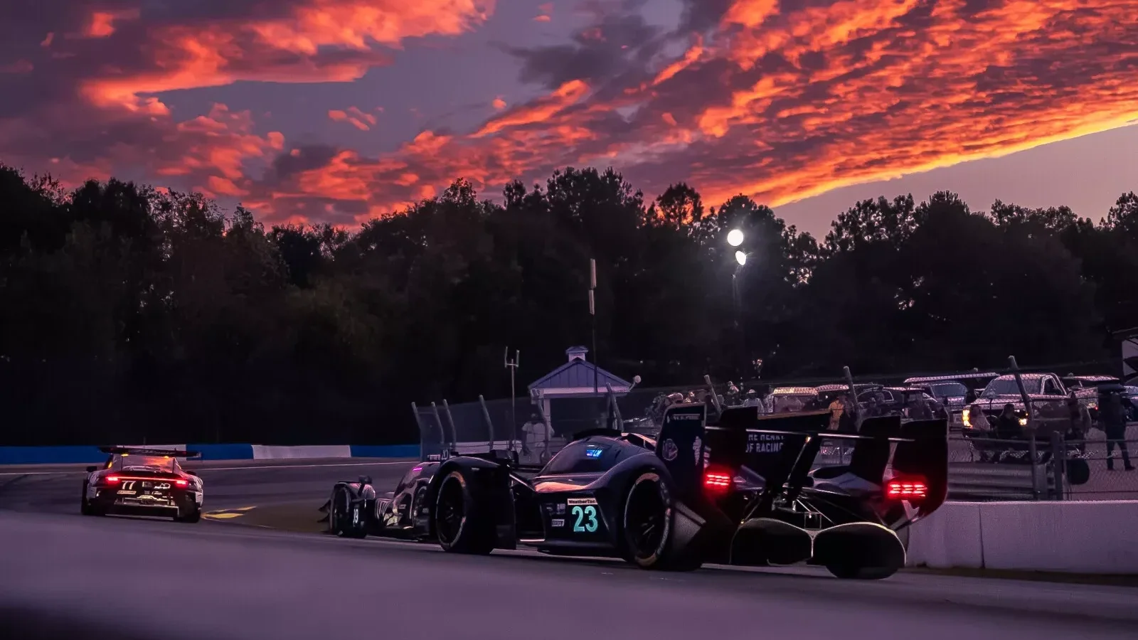 Aston Martin Valkyrie #23 rulând la apus pe circuitul Road Atlanta, în timpul unei sesiuni IMSA.