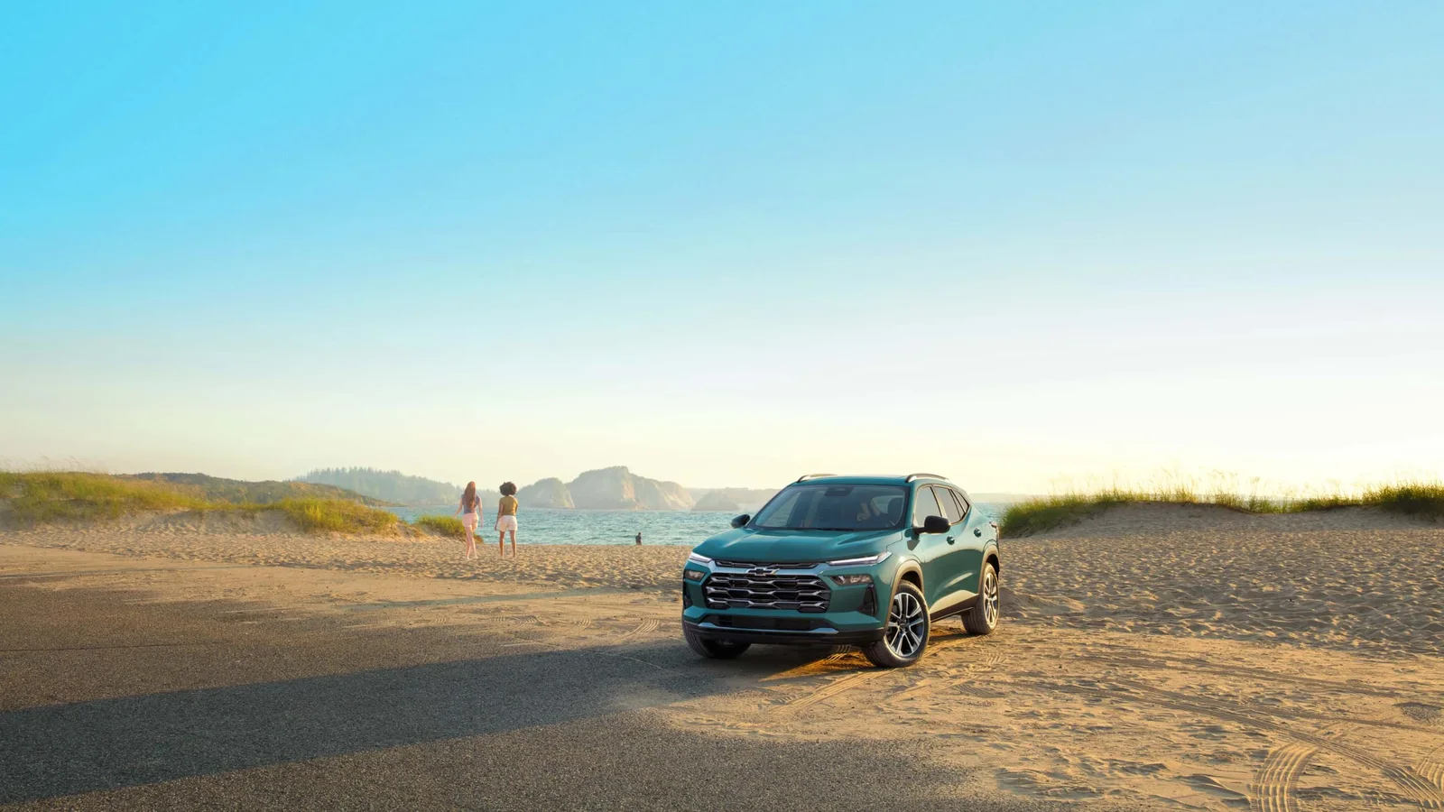Chevrolet Trax ACTIV 2027, parcat pe plajă, cu marea și dunele în fundal.
