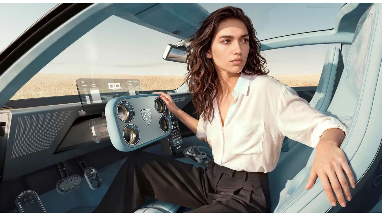 O femeie stă la volanul unui concept Peugeot, într-un interior cu comandă de direcție Hypersquare și ecrane digitale.