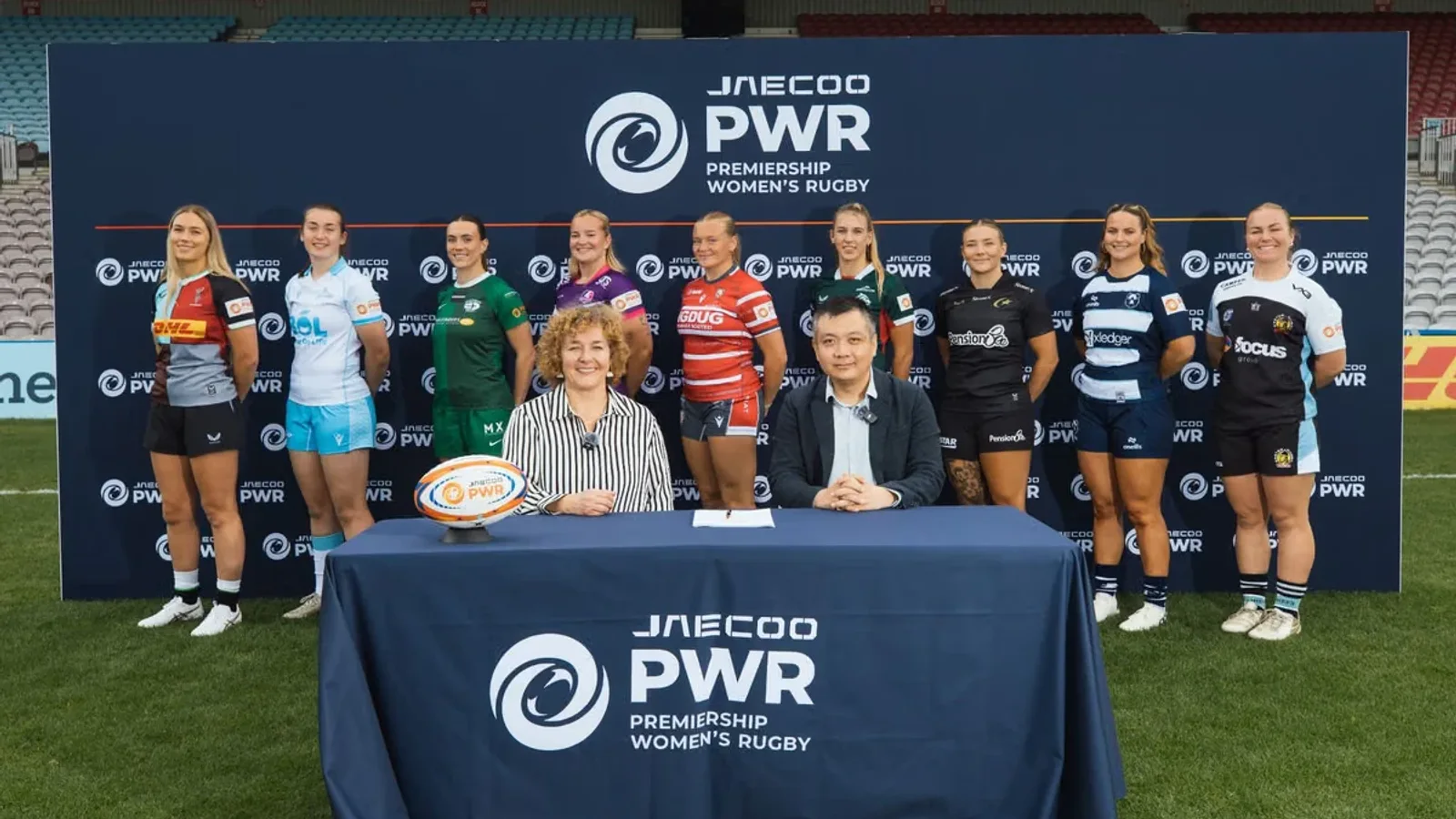 Reprezentanți JAECOO și Premiership Women’s Rugby semnează parteneriatul, alături de jucătoare ale celor nouă cluburi din competiție.