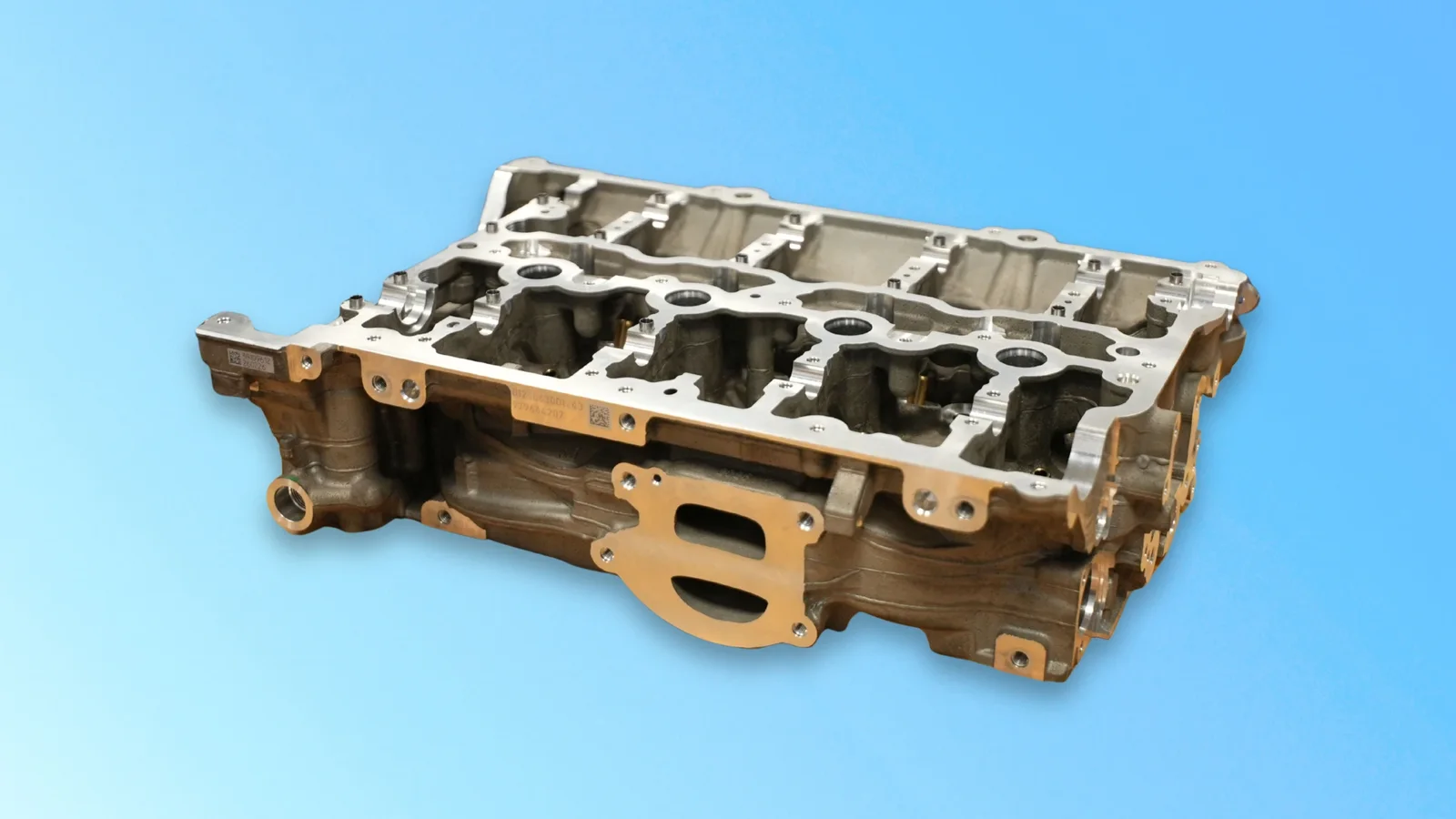 Bloc motor din aluminiu produs pentru noul BMW Seria 3, fotografiat pe fundal albastru.
