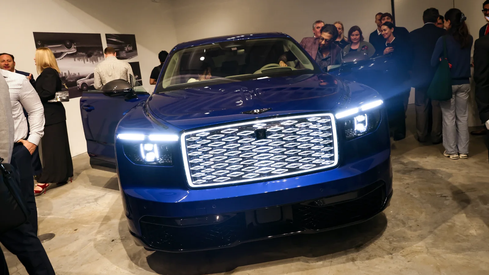 Bentley Torcal albastru, expus cu grila și farurile iluminate într-o galerie aglomerată din New York.