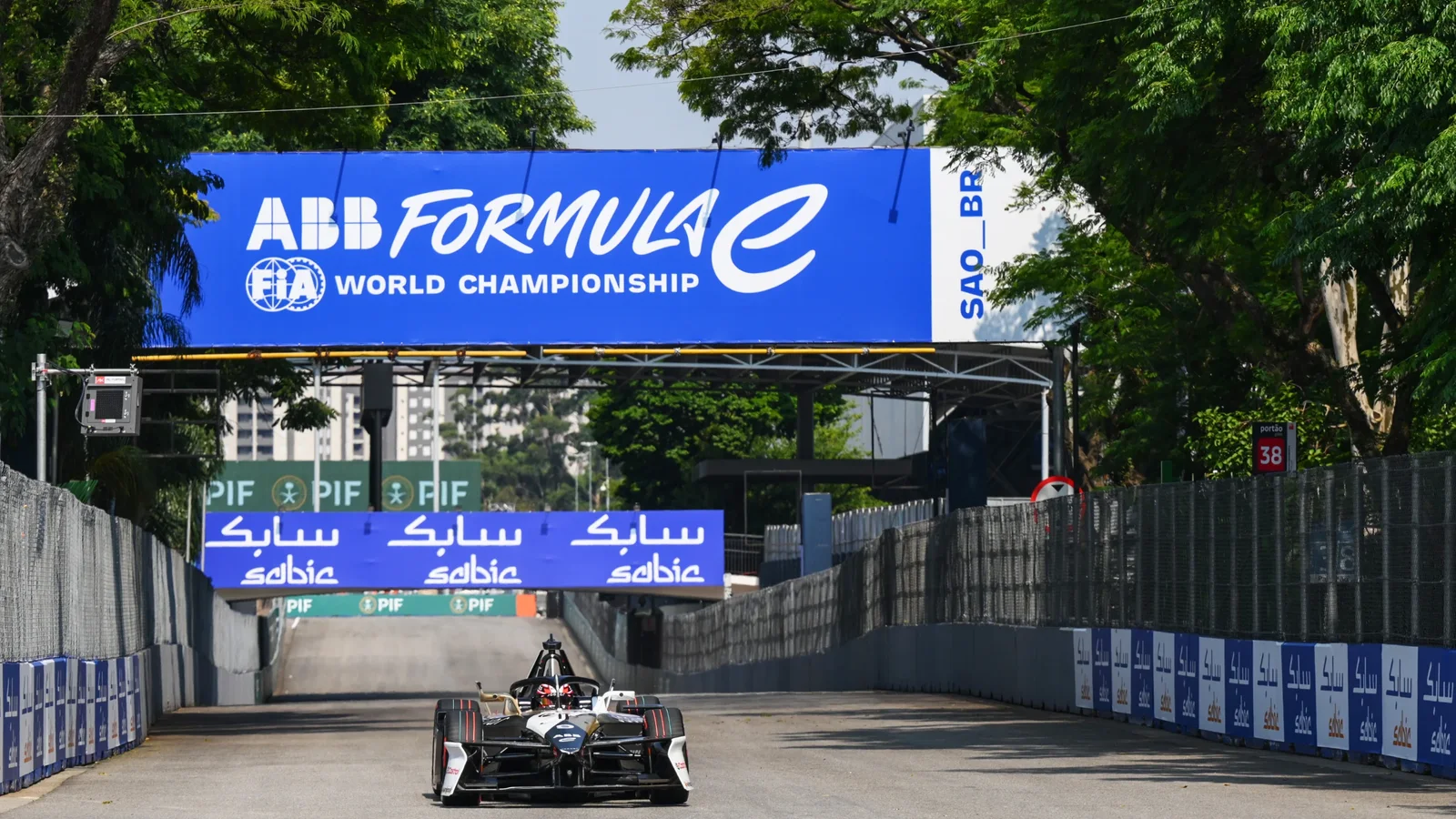 Monopost de Formula E pe circuit stradal, sub un panou ABB Formula E World Championship.
