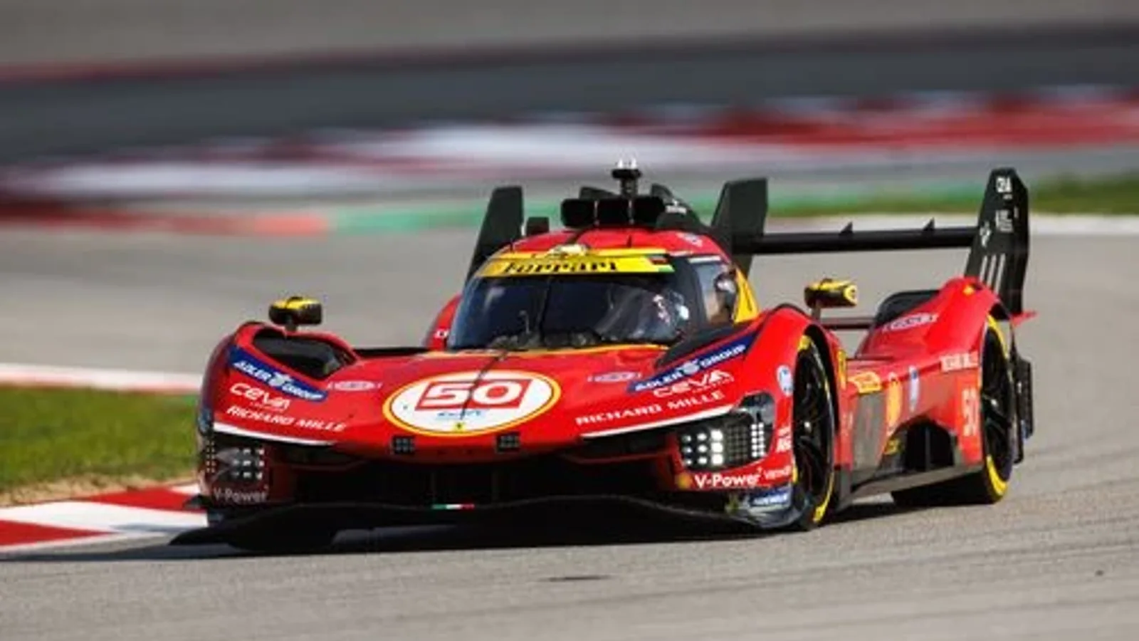 Ferrari 499P roșu și negru pe circuitul de la Monza, fotografiat din față laterală în timpul unei curse, mașina intră în viraj pe asfalt cu borduri albe și roșii. Detalii aerodinamice și embleme Ferrari vizibile pe caroserie.