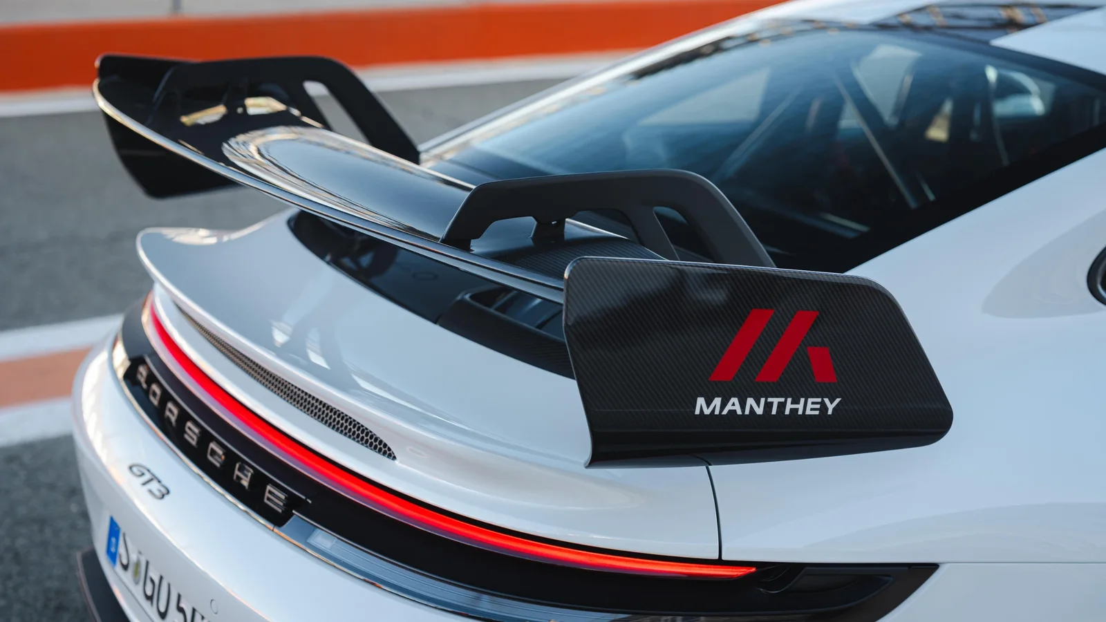 Detaliu al eleronului spate cu logo Manthey, montat pe un Porsche 911 GT3 alb