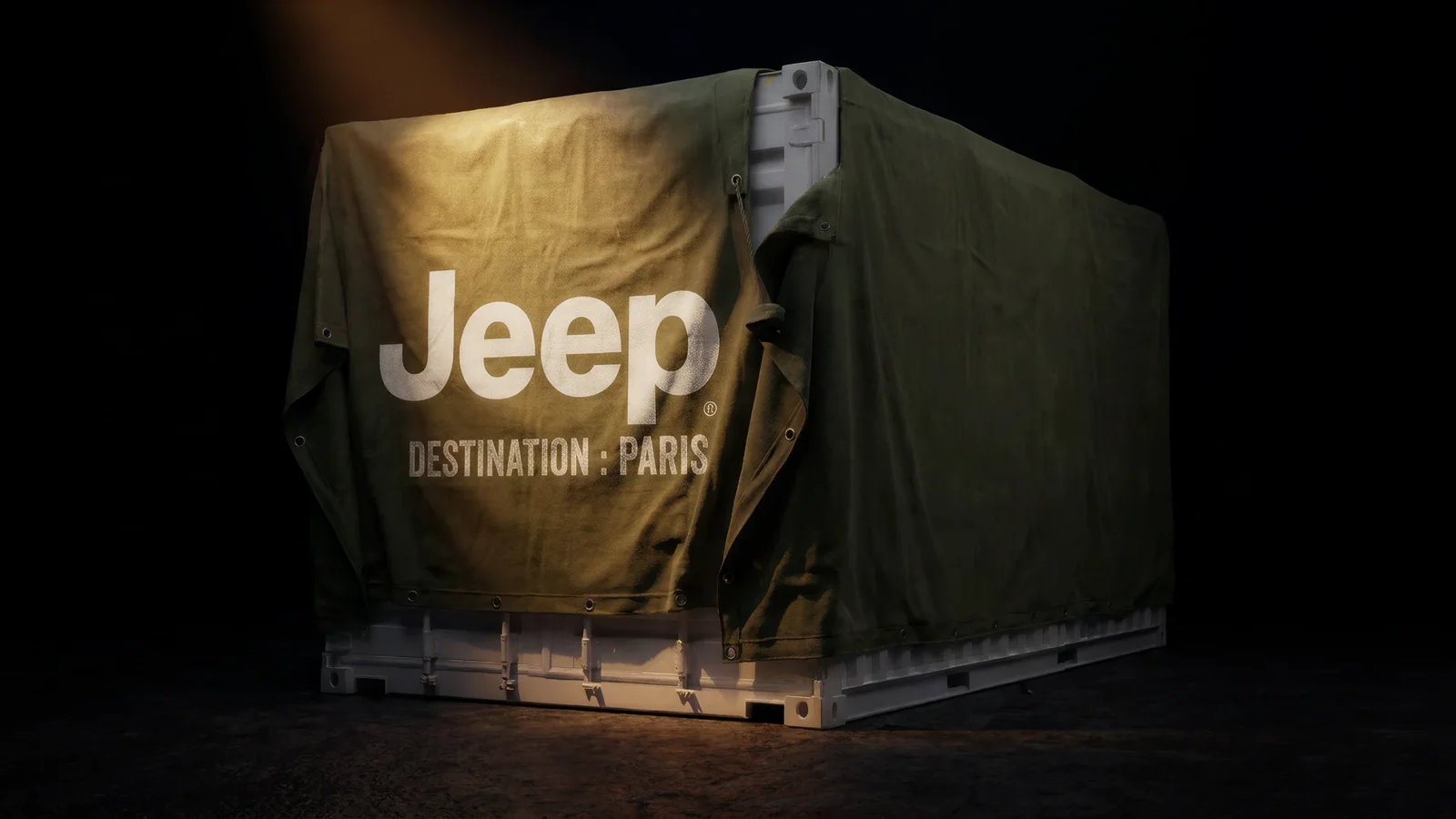 Container acoperit cu prelată inscripționată „Jeep Destination: Paris”, iluminat într-un decor întunecat.