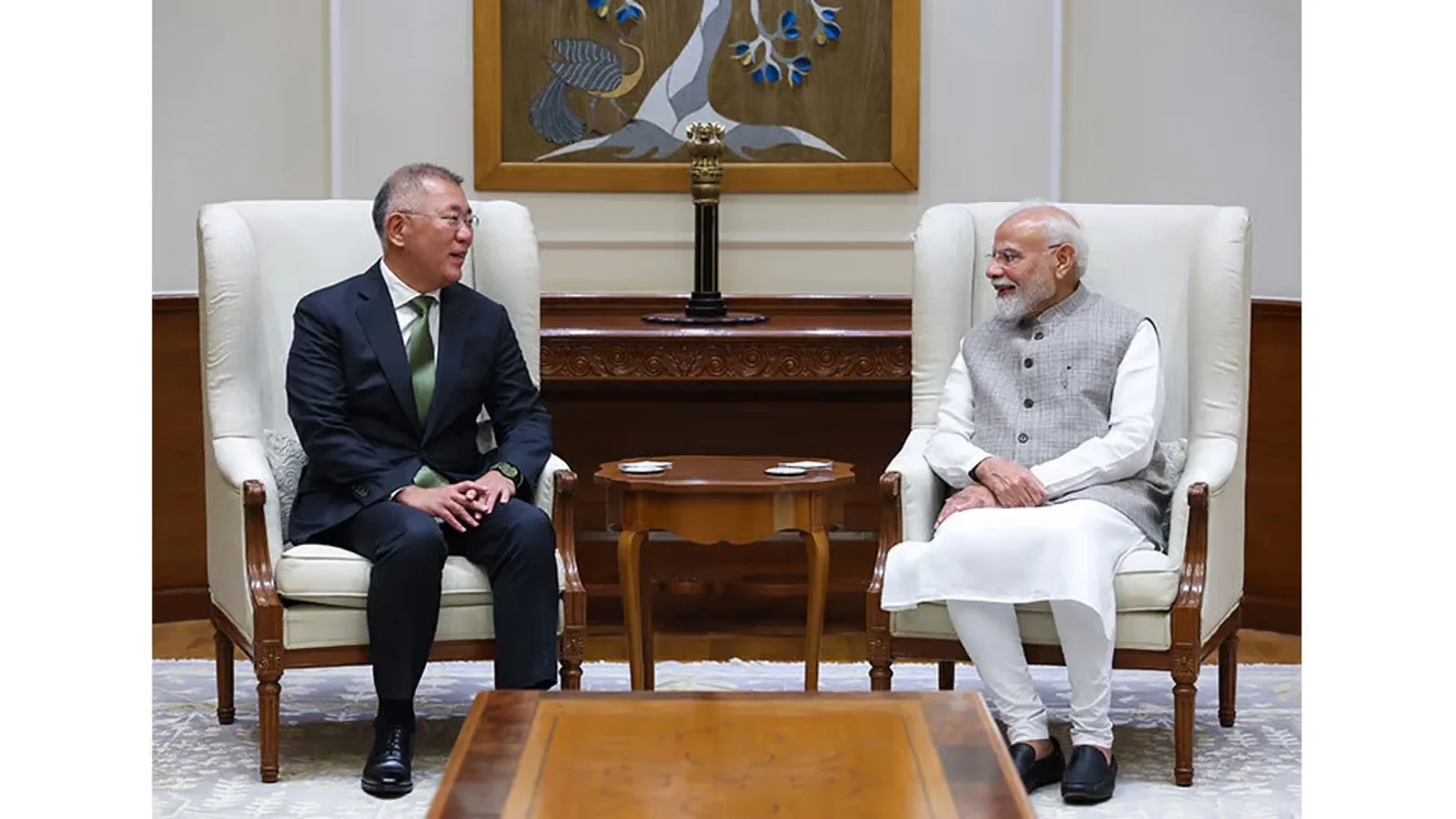 Narendra Modi și un oficial chinez stau de vorbă în timpul unei întâlniri oficiale, într-un salon cu fotolii albe.