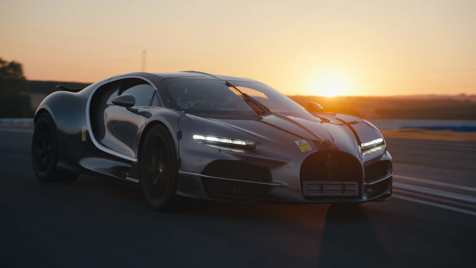 Bugatti Tourbillon în timpul unui test la apus, pe circuit, cu luminile LED aprinse.