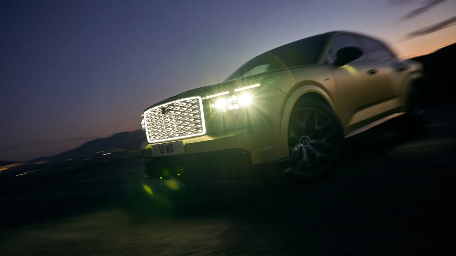 Bentley Torcal electric, fotografiat din față pe un drum de munte la apus.