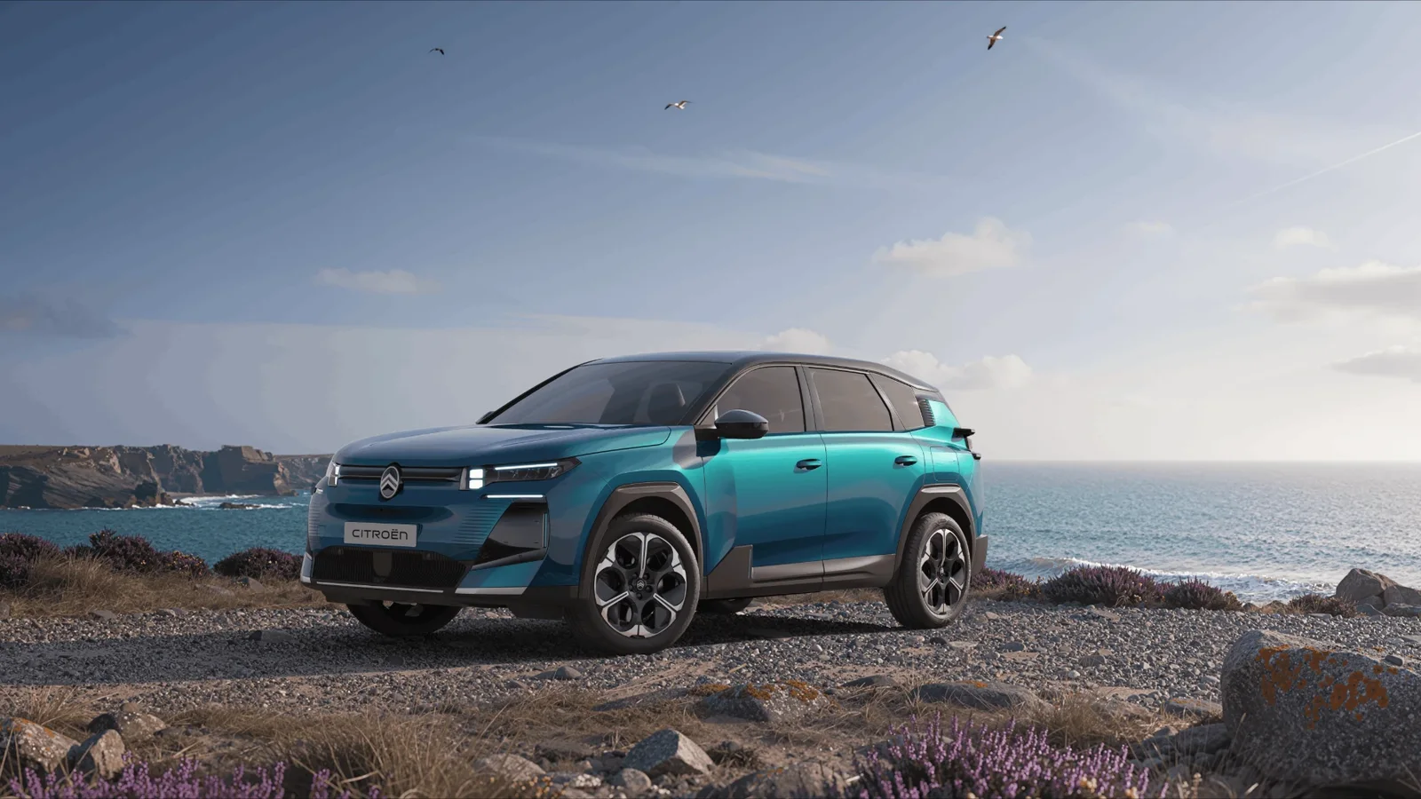 Citroën C5 Aircross Émeraude albastru, văzut din față pe un țărm stâncos, cu marea în fundal.