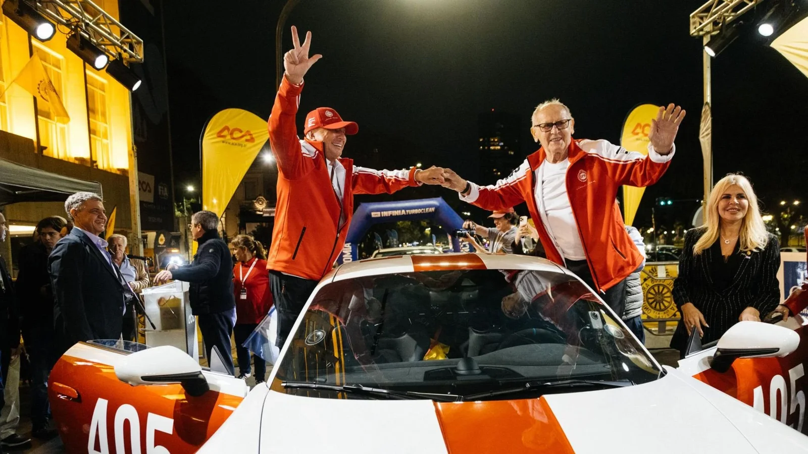 Participanți la Gran Premio salută publicul de pe Porsche-ul de raliu cu numărul 405.