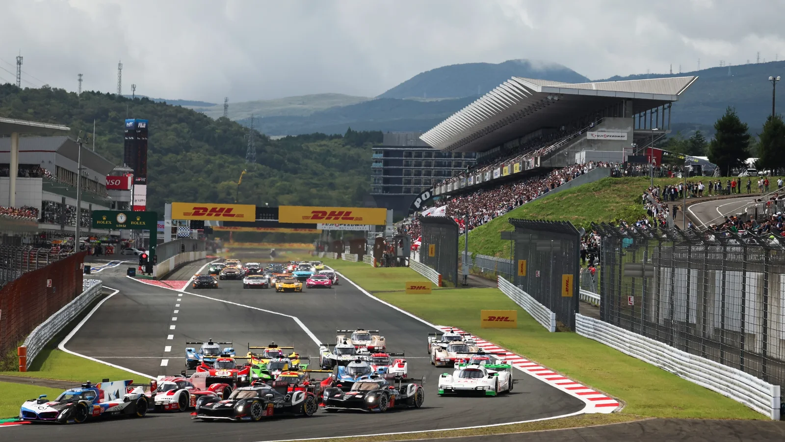 Startul unei curse de anduranță pe Fuji Speedway, cu prototipuri și mașini GT în fața tribunelor pline.